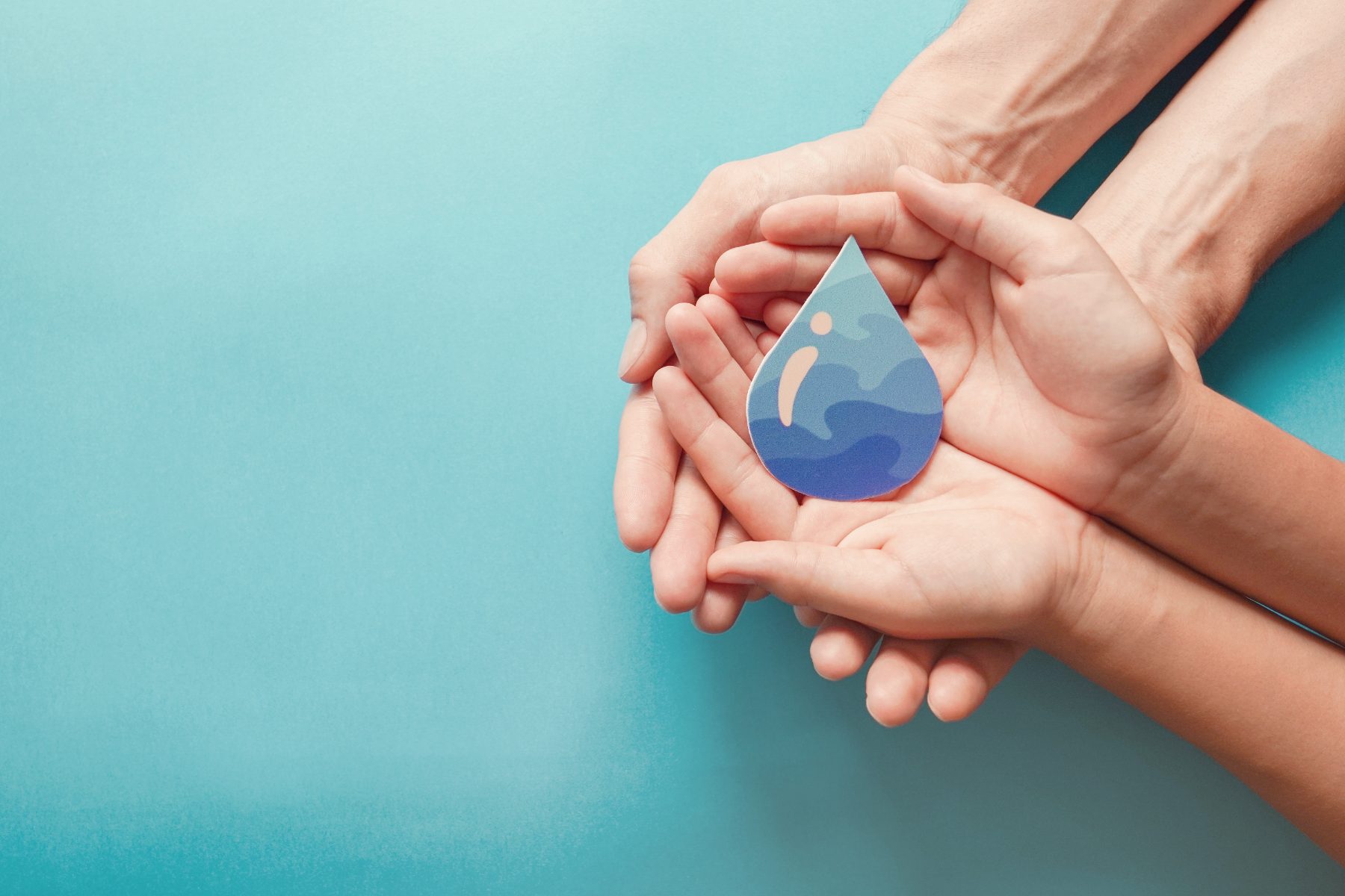 Mains tenant une goutte d'eau, symbole d'une gestion durable de l'eau en hôtellerie