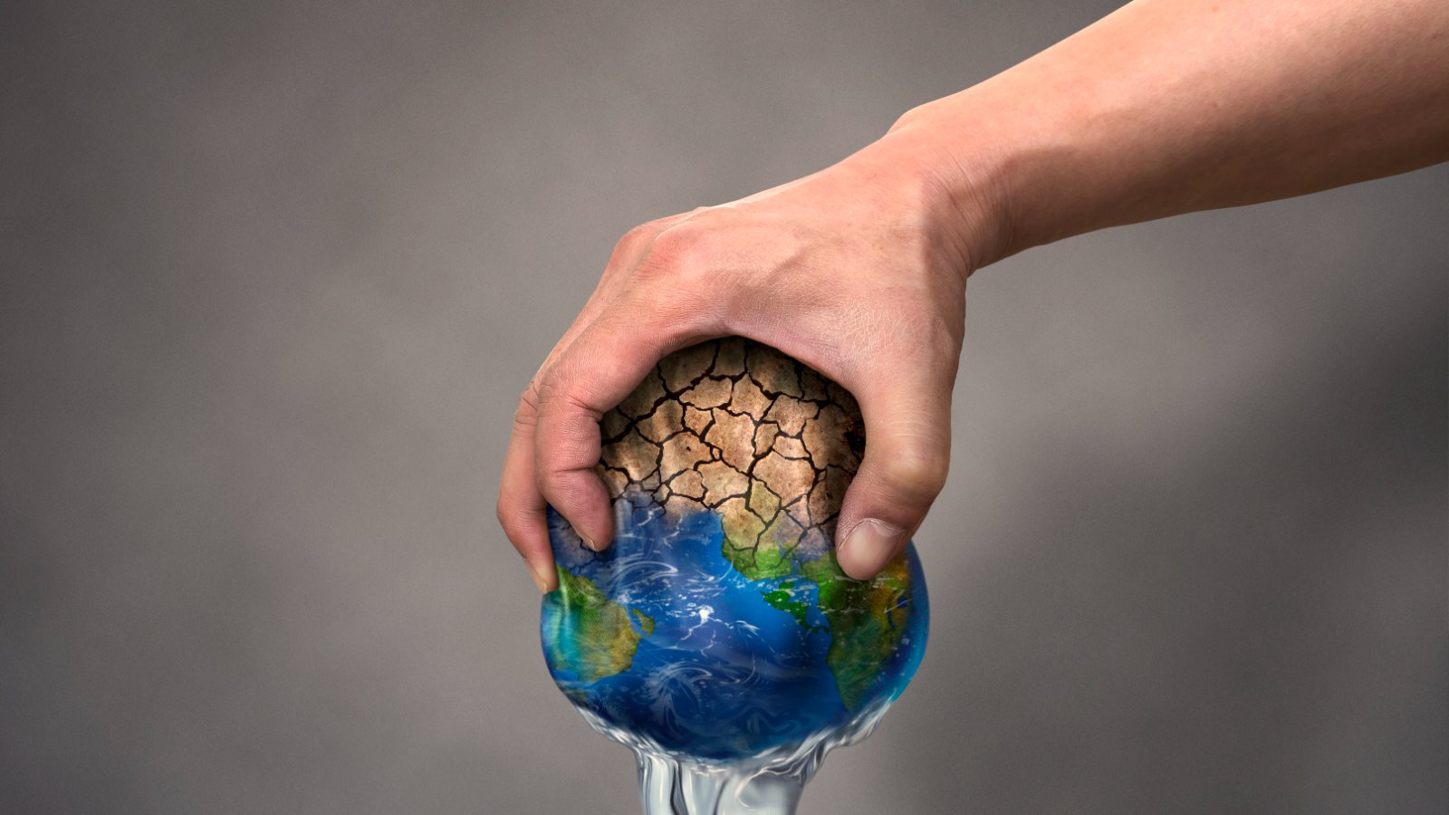 Une main presse la Terre comme une éponge, l'eau s'en échappe et la surface se craquelle : illustration du stress hydrique